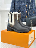 Black ankle boots with plush white shearling trim and dark rubber lug sole