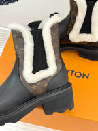 Black ankle boot with white shearling collar and brown monogram panel on quarter