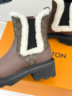 Close-up of brown Louis Vuitton ankle boot with monogram side panel and white sherpa trim