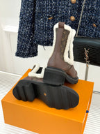 Back view of brown Louis Vuitton ladies ankle boots on orange box with lug soles