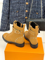 Tan high-top lace-up boots with gold studded trim and chunky black platform sole