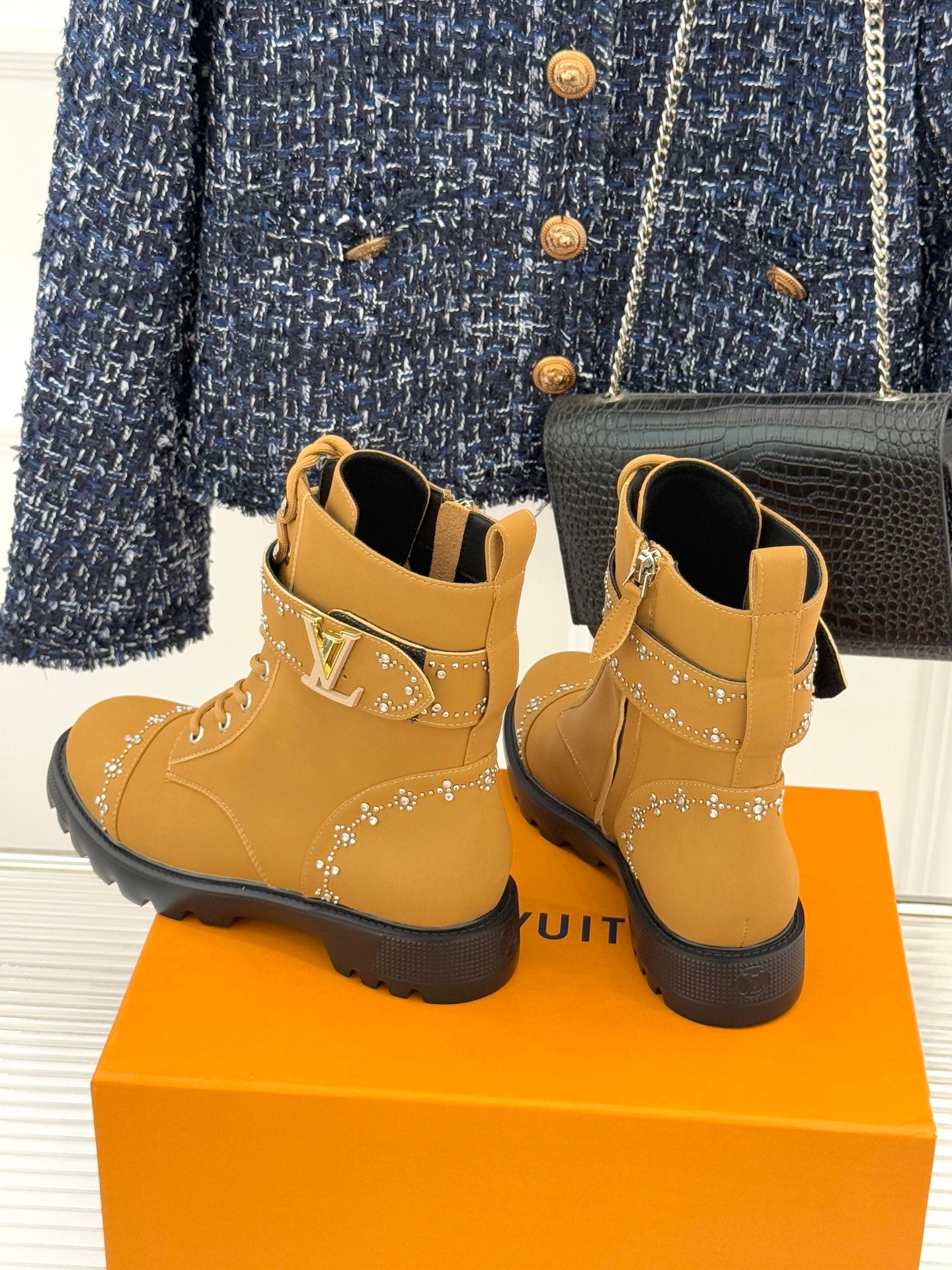 Tan high-top lace-up boots with gold studded trim and chunky black platform sole