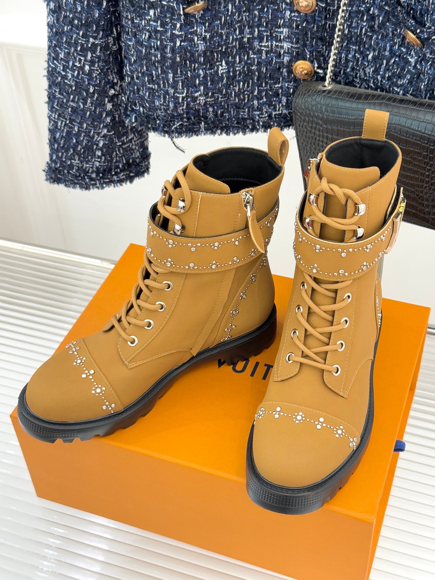 Tan high-top lace-up boots with gold studded accents and padded ankle collar