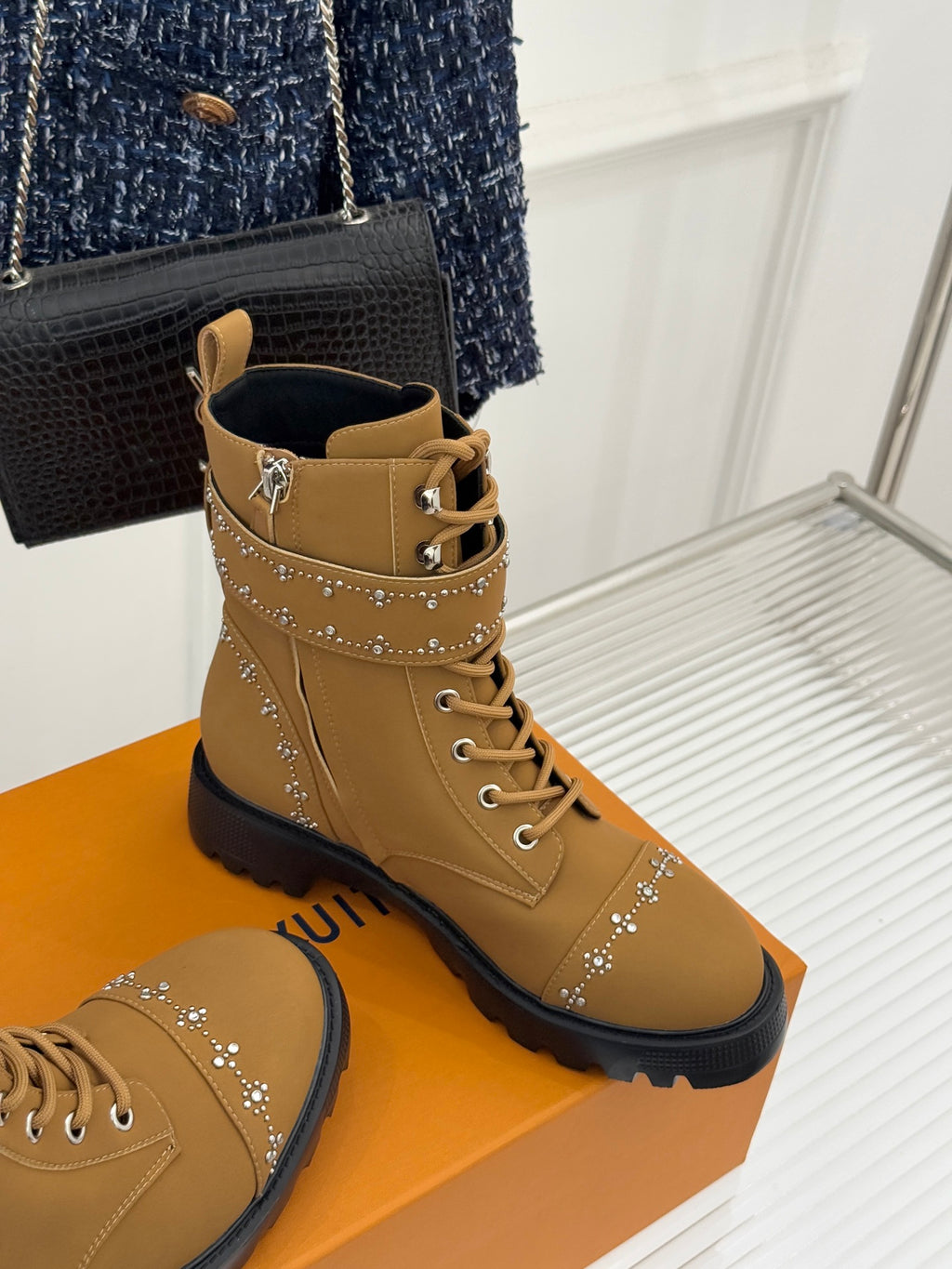 Tan high-top lace-up boots with gold studded side trim and black lug sole