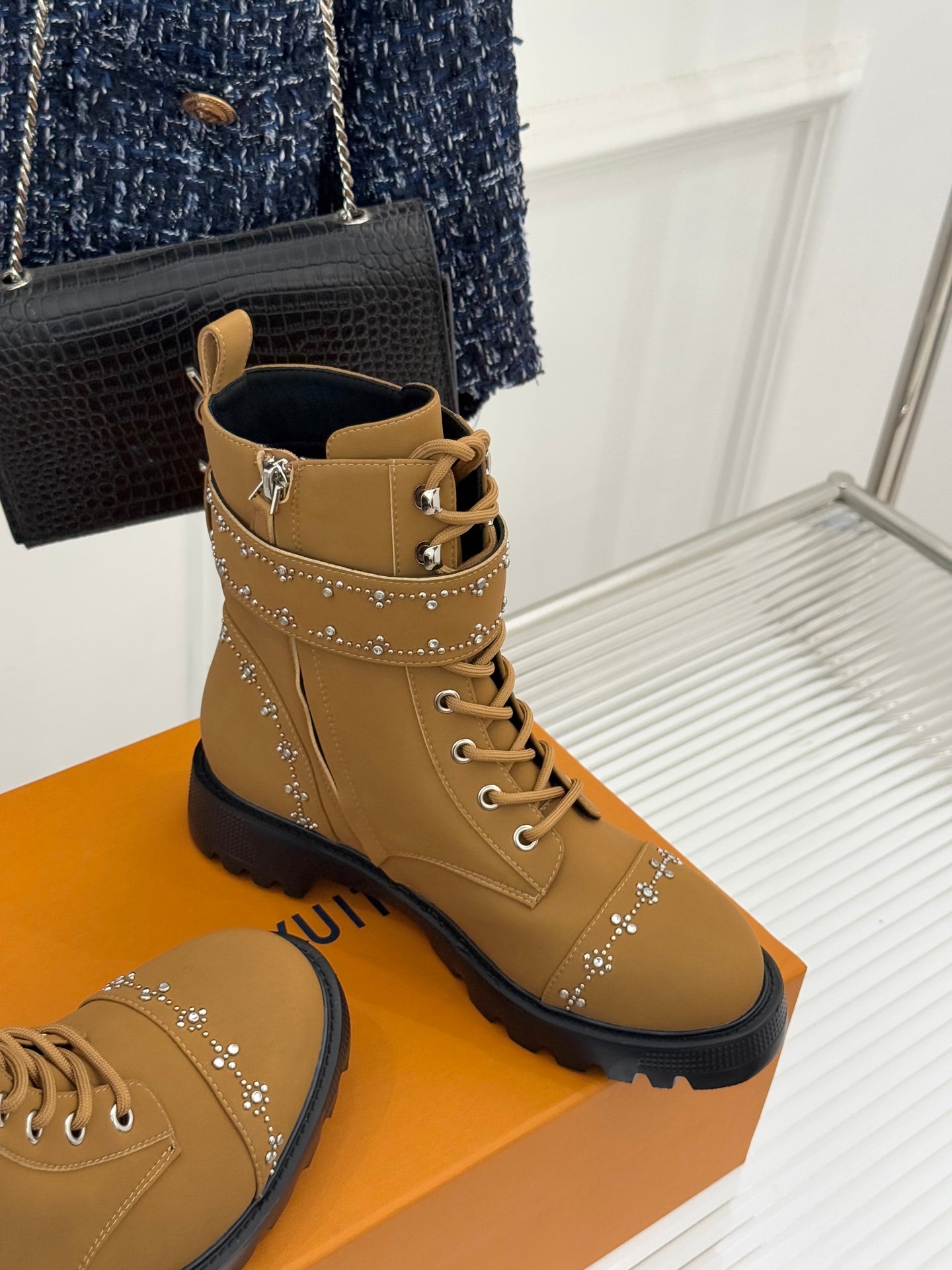 Tan high-top lace-up boots with gold studded side trim and black lug sole