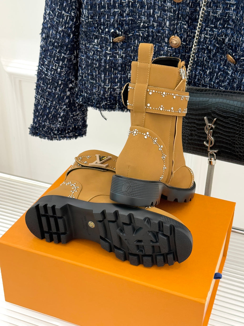 Tan high-top boot with treaded rubber outsole and gold studded trim