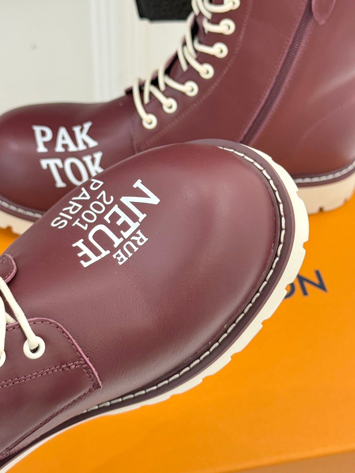 Burgundy Louis Vuitton lace-up ankle boot toe detail with printed text and white laces