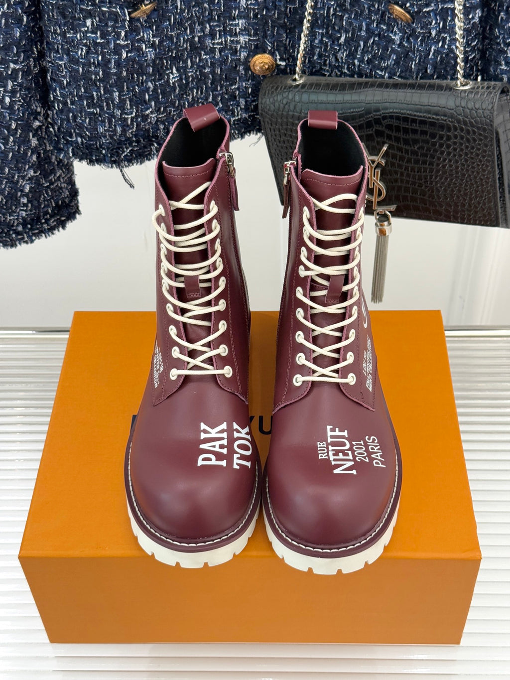 Burgundy Louis Vuitton lace-up ankle boots with front laces and LV/V emblems, chunky white sole