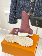 Burgundy Louis Vuitton lace-up ankle boots showing outsole tread, on orange box
