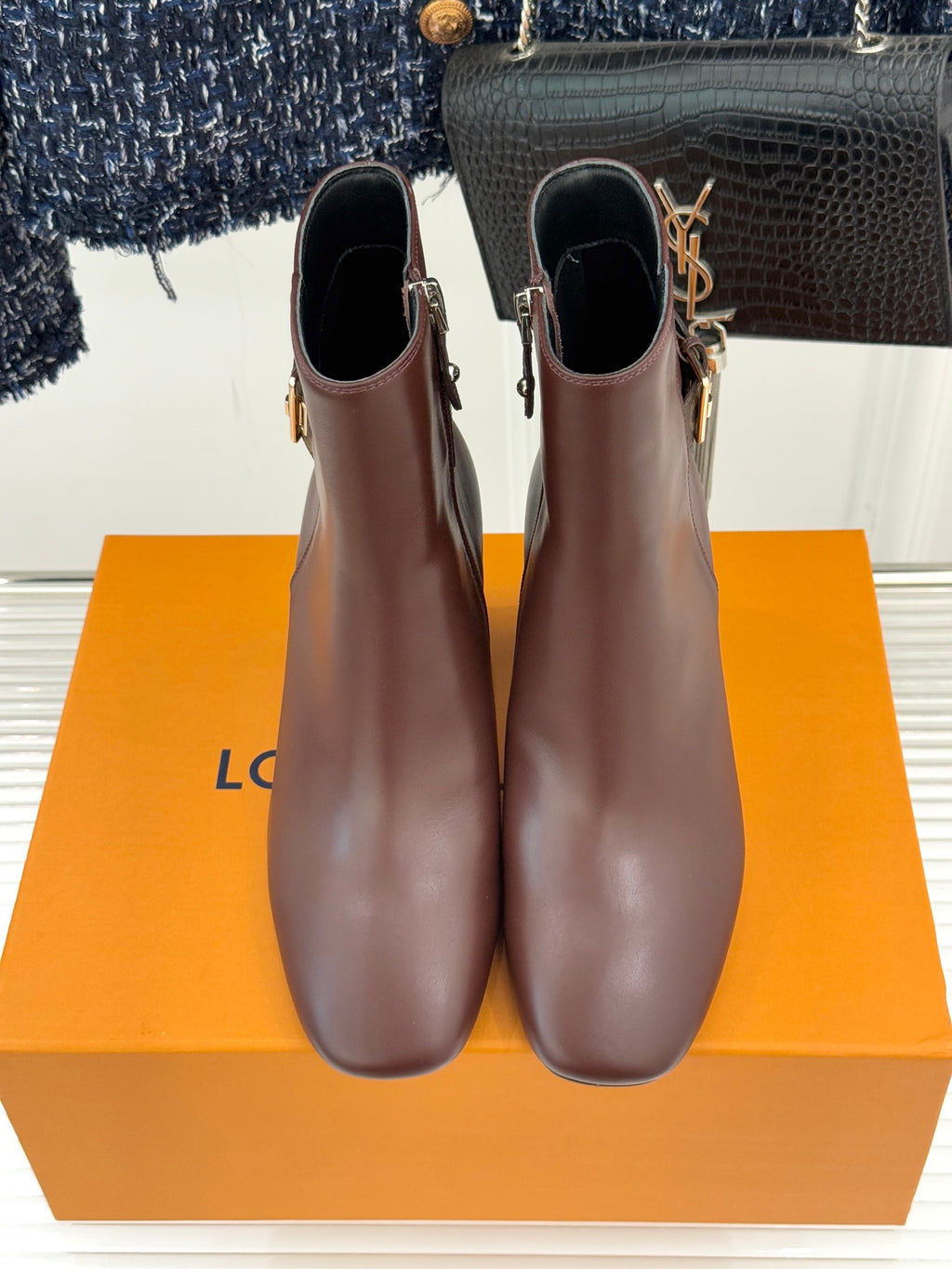 Brown leather ankle boots standing side by side, side zipper and block heel