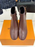 Brown leather ankle boots standing side by side, side zipper and block heel