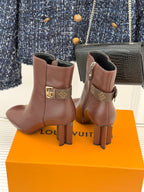 Brown leather ankle boots with monogram buckle, side zipper, and stacked heel