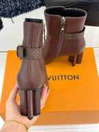 Brown leather ankle boots with side zipper, monogram strap, and block heel