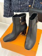 Pair of womens dark leather ankle boots with side zips and block heels, logo strap detailing.