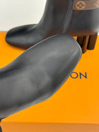 Womens dark leather ankle boot toe and upper with smooth finish, block heel visible.