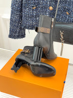 Womens dark leather ankle boots with side zip, block heels, and logo buckle strap detail.