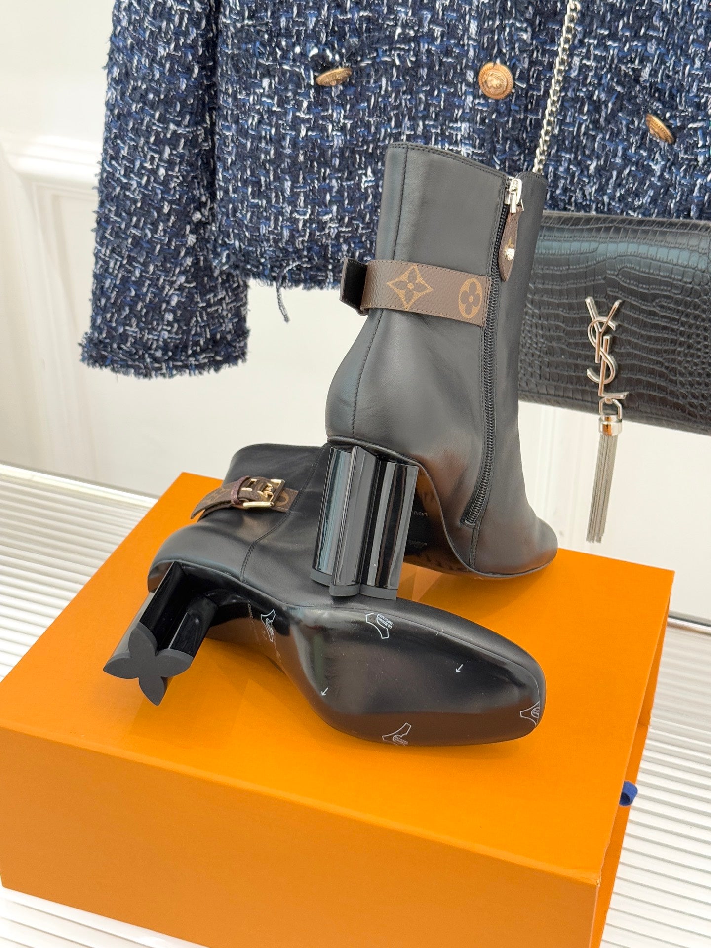 Womens dark leather ankle boots with side zip, block heels, and logo buckle strap detail.
