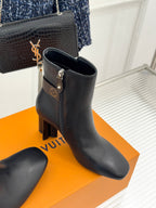 Womens dark leather ankle boot with side zip, block heel, and logo buckle strap.