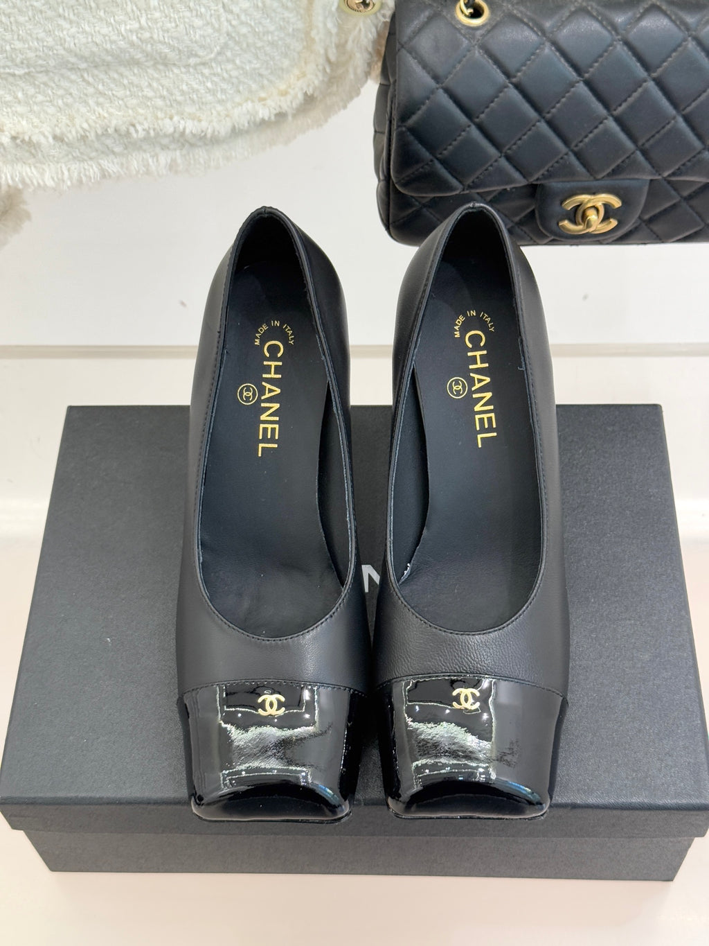 Black Chanel leather pumps, closed toe with patent trim and gold “CHANEL” branding