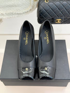 Black Chanel leather pumps, closed toe with patent trim and gold “CHANEL” branding