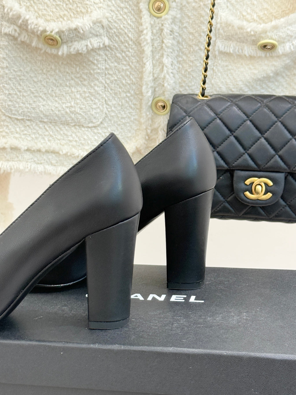 Black Chanel pumps close-up, sculpted block heel and smooth leather upper