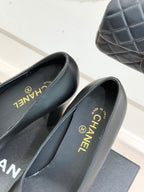 Black Chanel pumps showing insole text “MADE IN FRANCE” on box display
