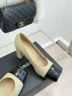 Beige high-heel pump with black glossy buckle strap and gold CC detail, single