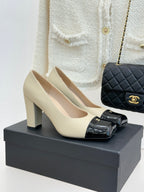 Beige high-heel pumps with black patent buckle strap and gold CC detail