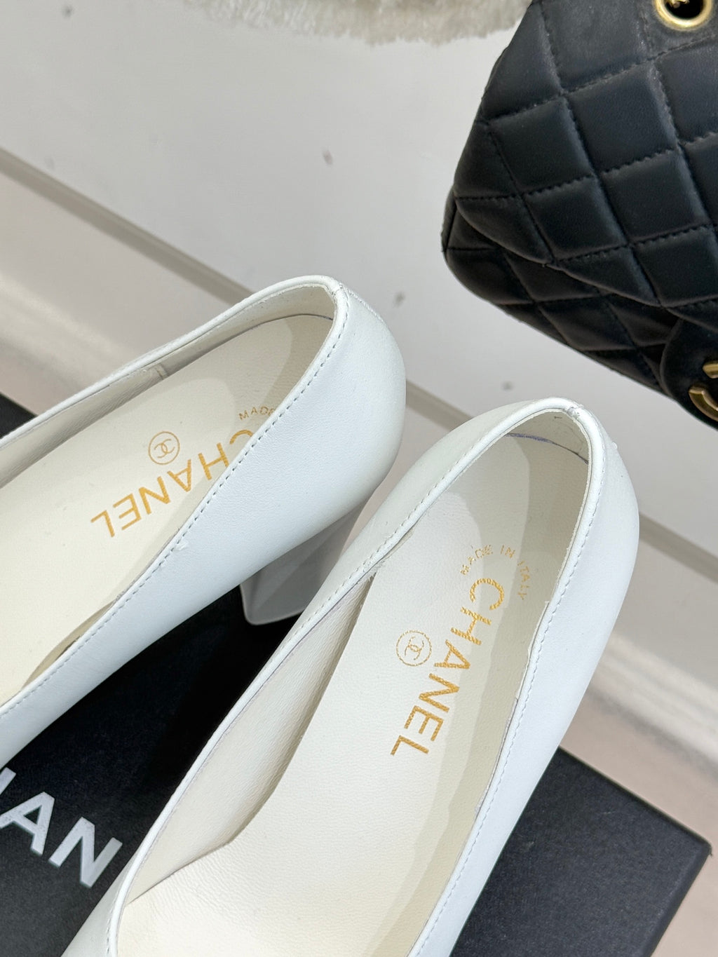 Women’s Chanel white pumps with black patent toe trim and beige insole