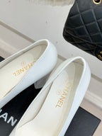 Women’s Chanel white pumps with black patent toe trim and beige insole