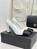 Women’s Chanel white pumps with black patent toe cap and block heel