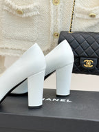 Women’s Chanel white pumps with black patent trim and square-toe block heel