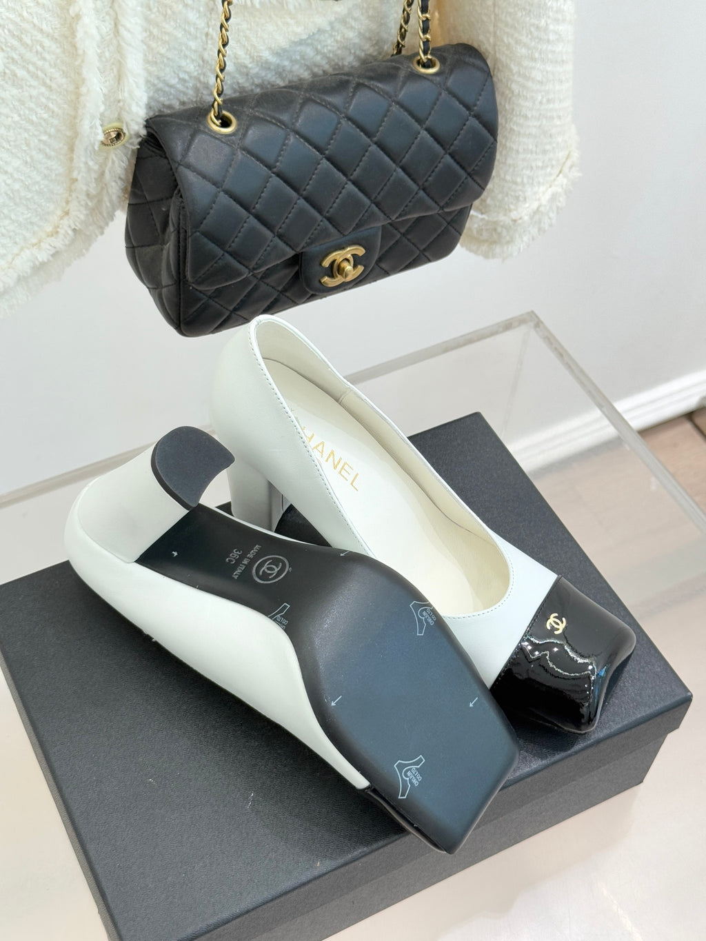 Women’s Chanel white pumps with black patent toe caps and block heel