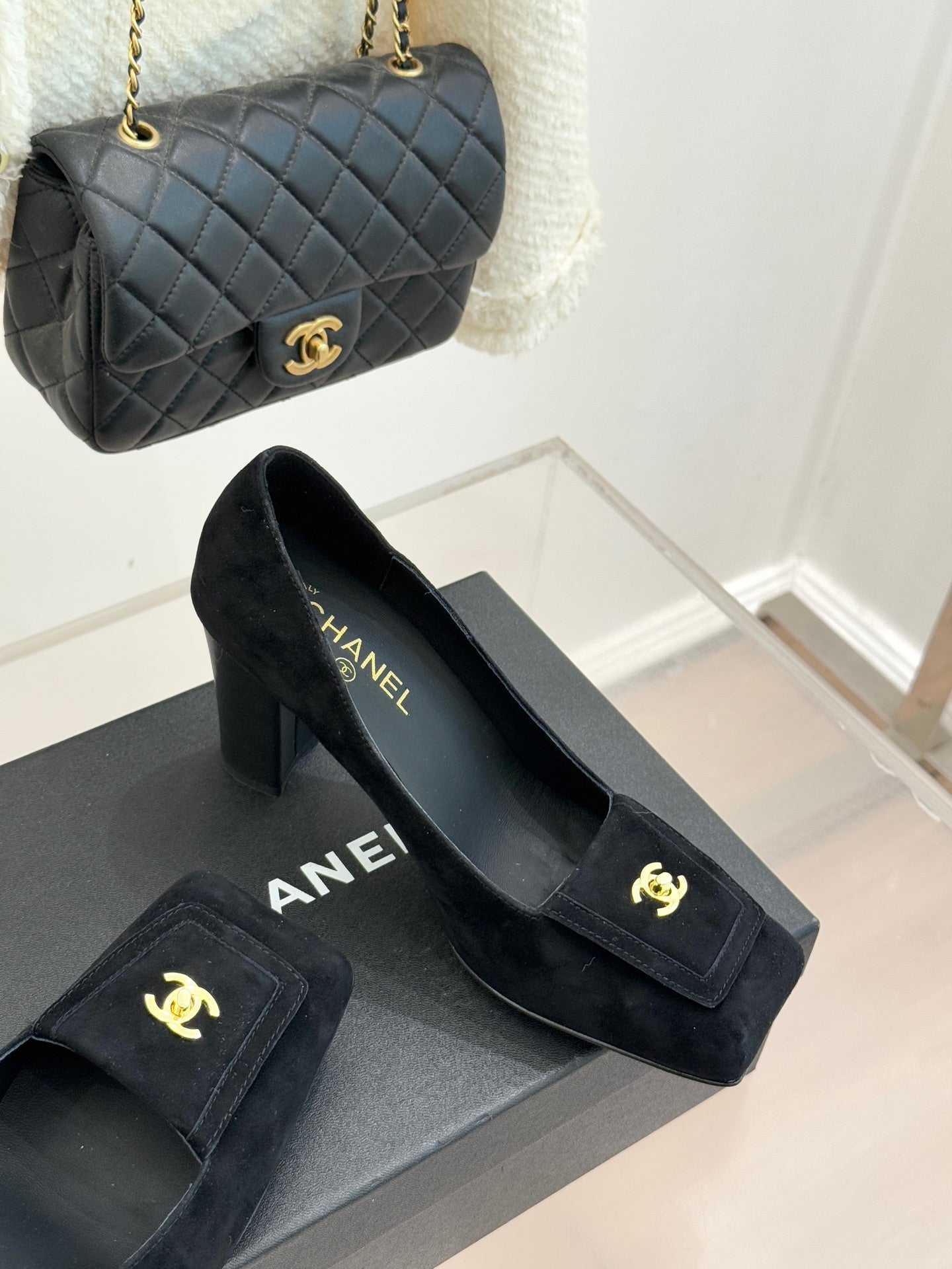 Black suede heeled loafers with gold CC emblem and slip-on profile