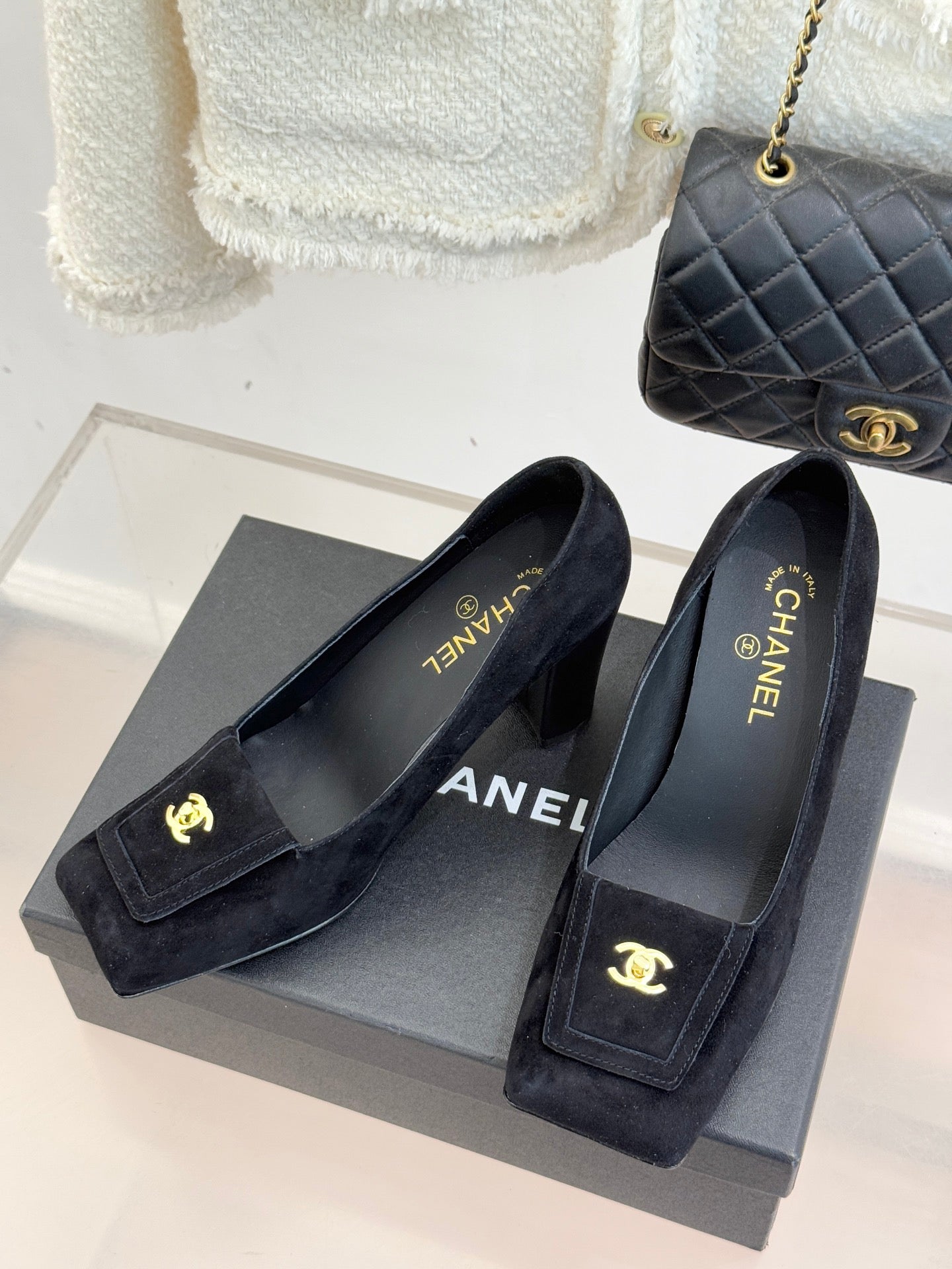 Black suede loafers with gold CC emblem, slip-on design and block heel