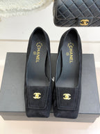 Black suede pointed-toe shoes with gold CC emblem on front patch