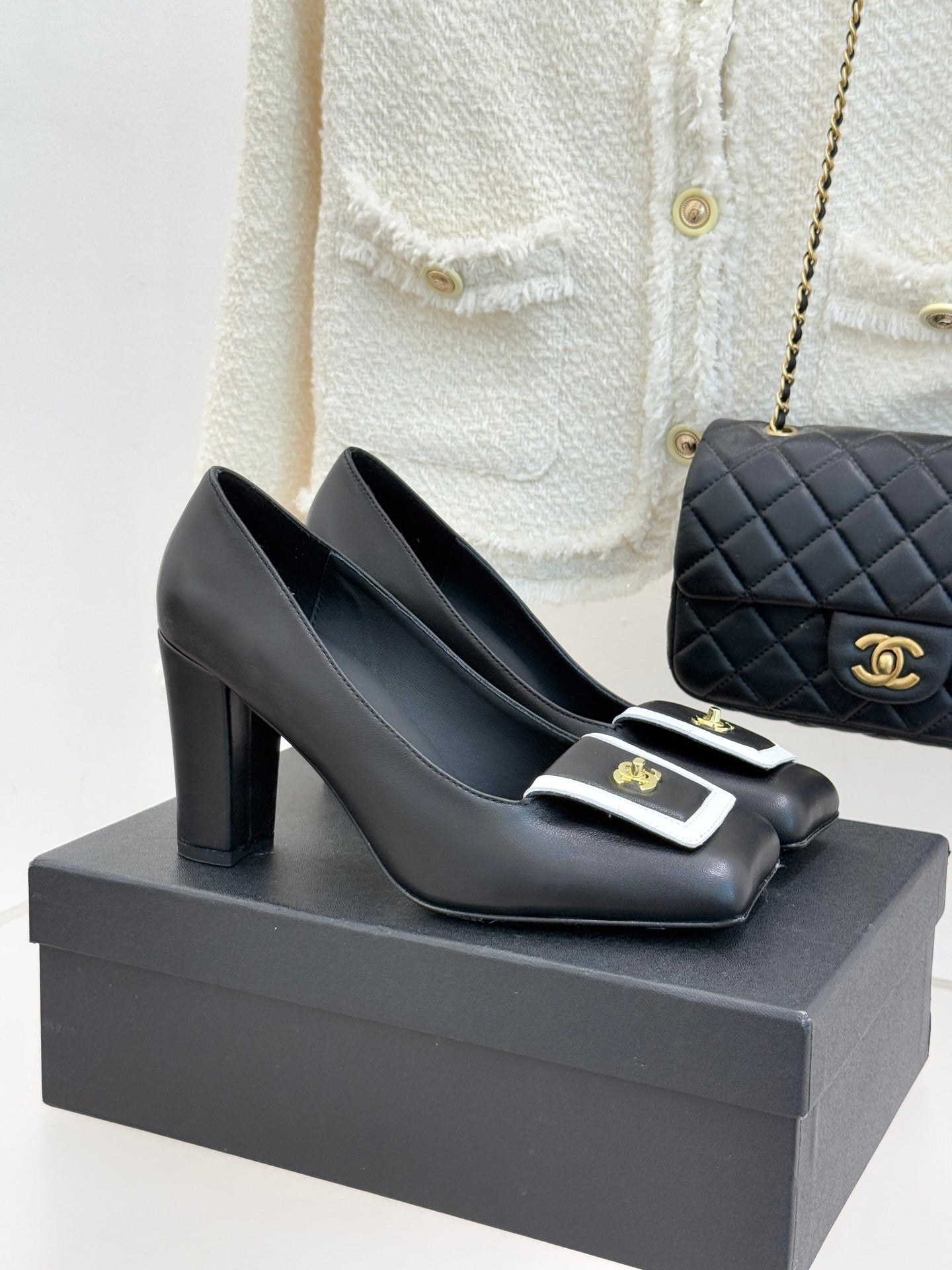 Black Chanel ladies heeled mules with white-trim buckle and gold emblem