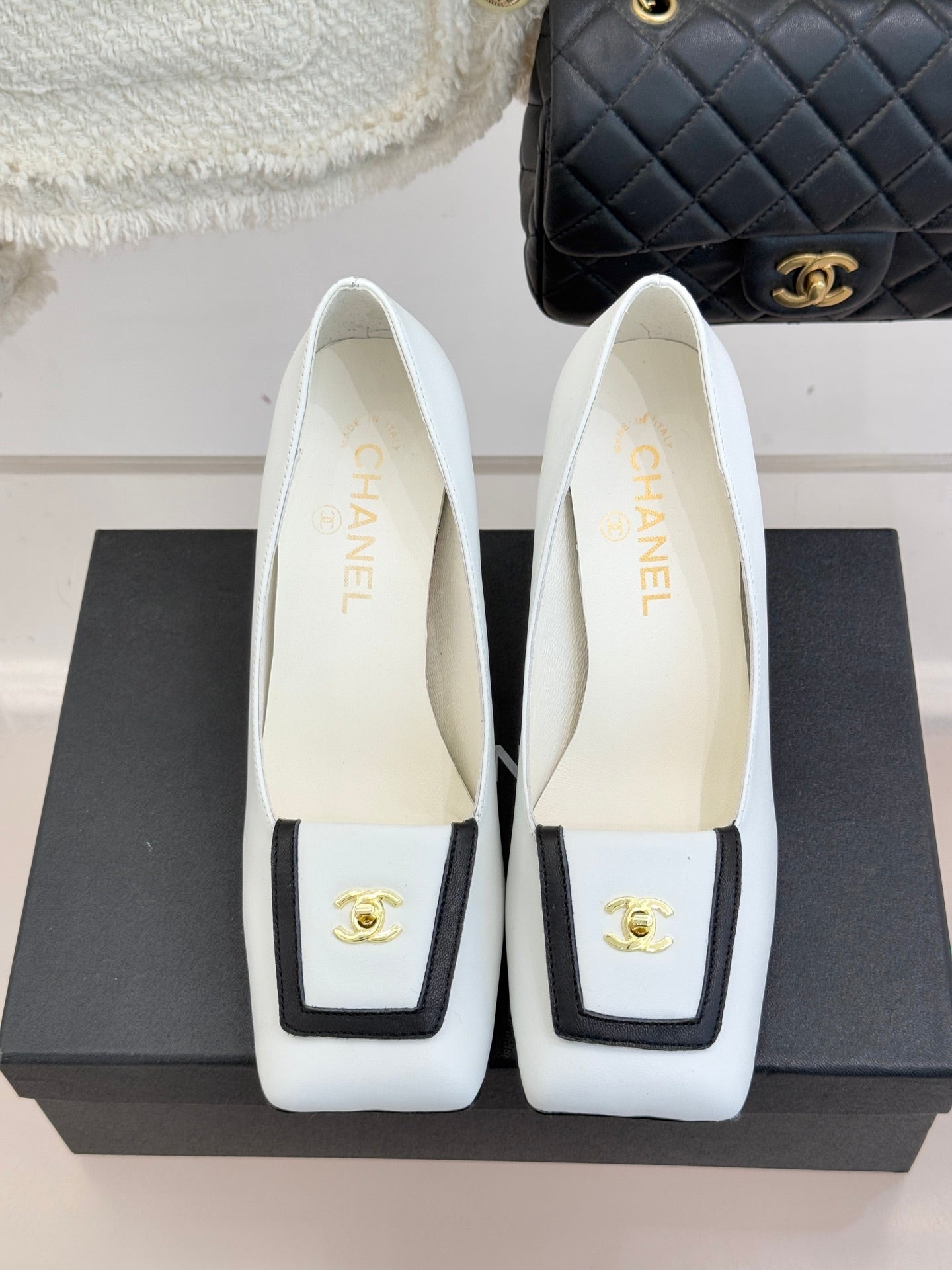 Pair of white leather block-heel pumps with gold logo on front and insoles