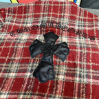 Red plaid coat with black faux-leather cross applique on front