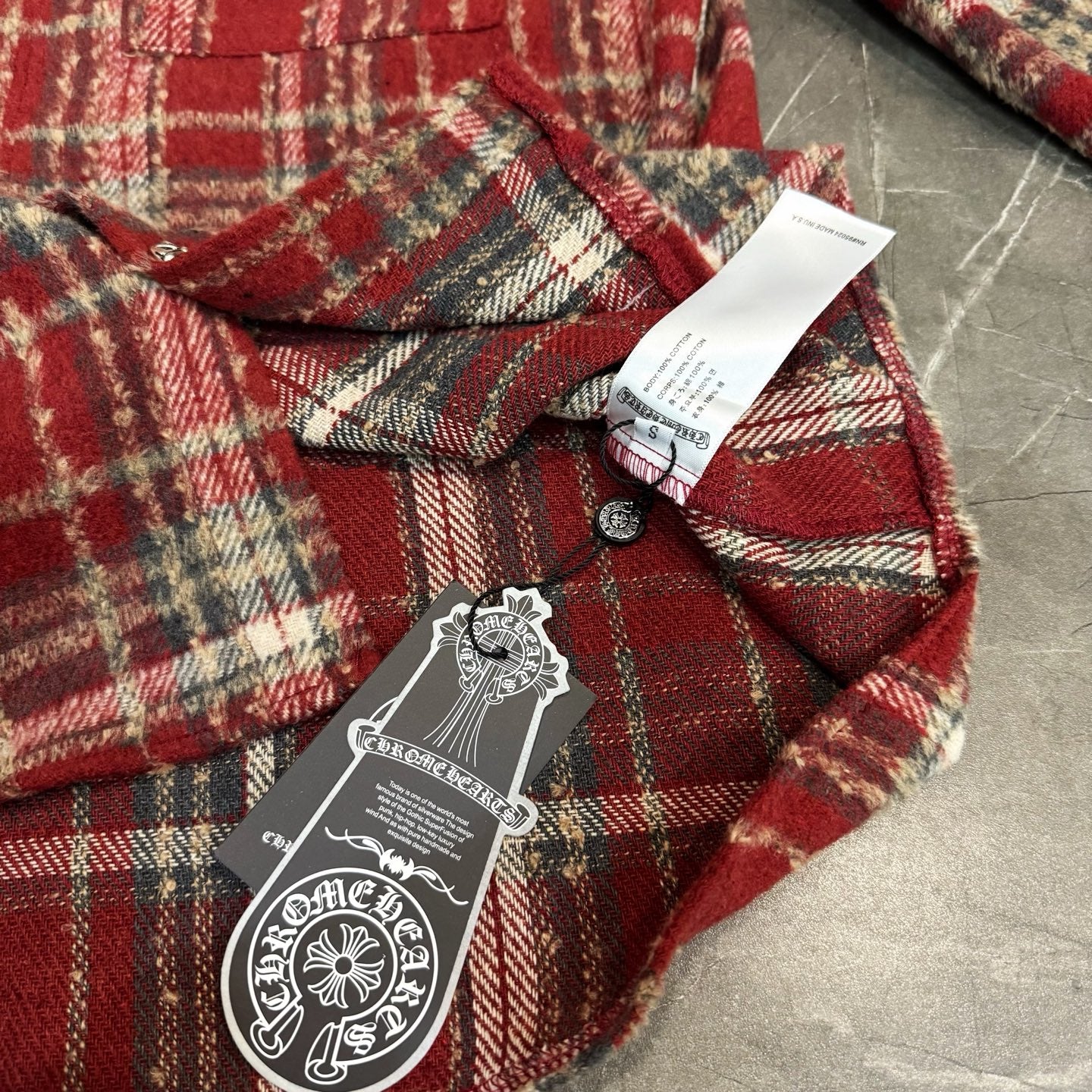 Red plaid coat with stand collar, front buttons, and hanging tag