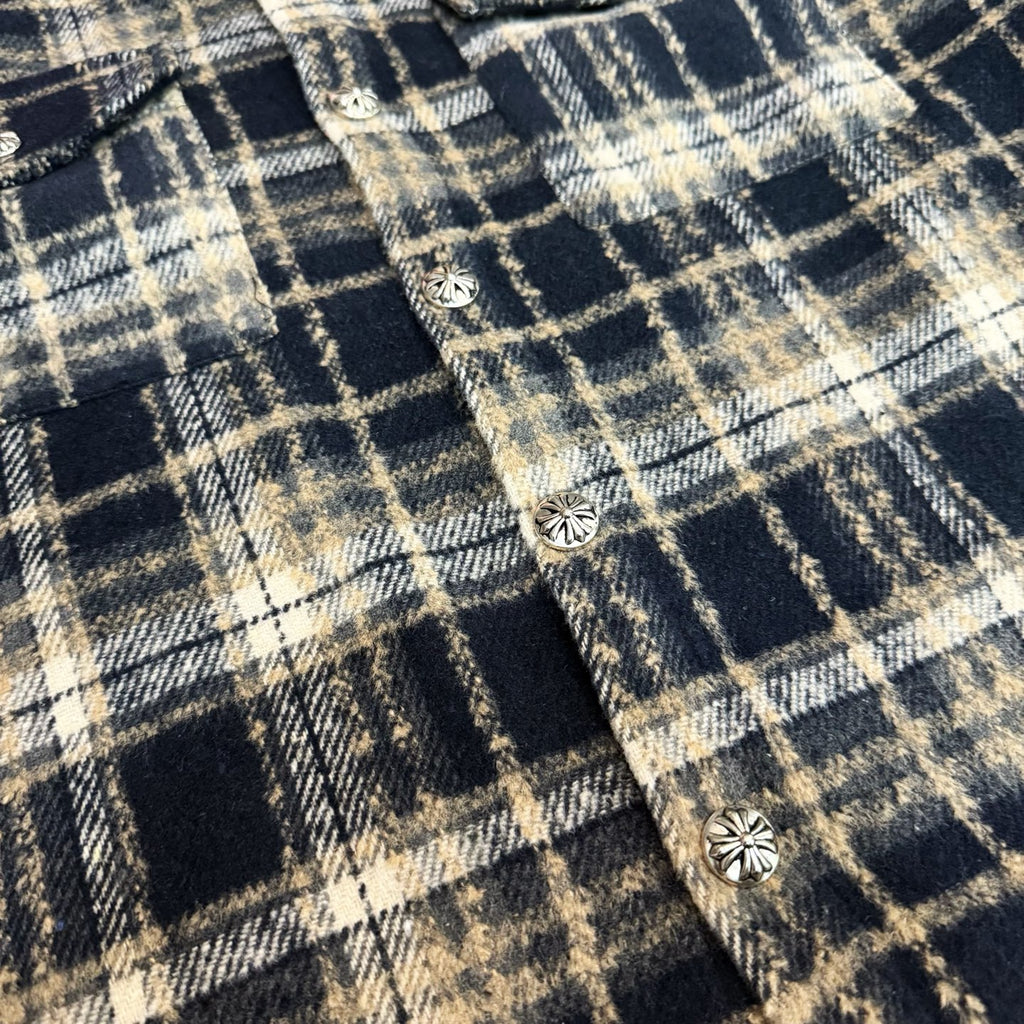 Close-up of navy-and-cream plaid fabric with small round decorative buttons