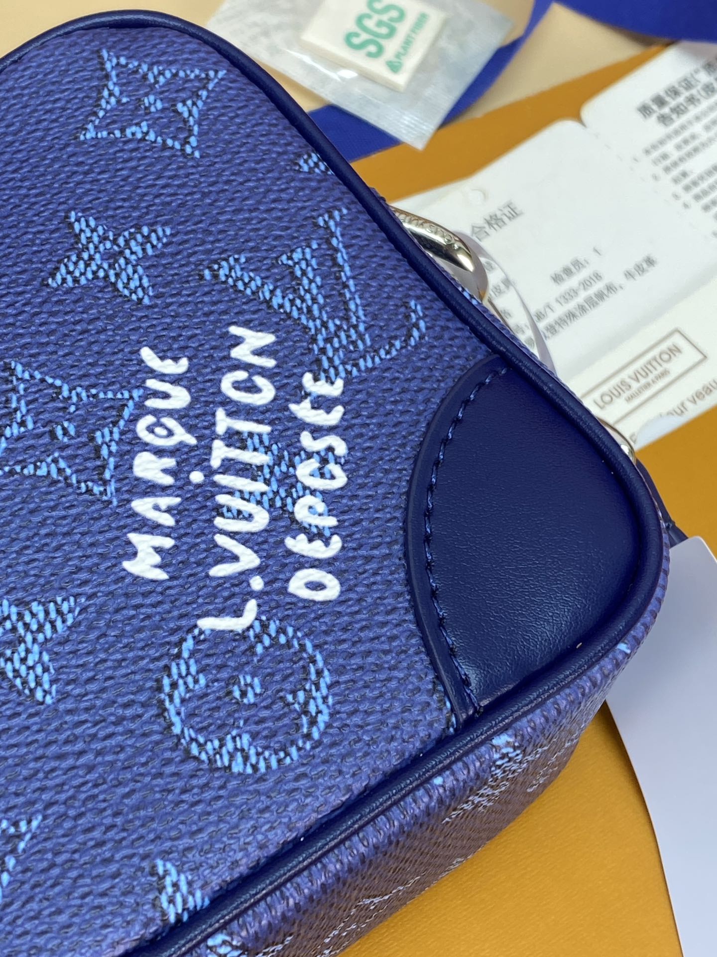 Men's Louis Vuitton bag blue monogram exterior with metal zipper and embossed text