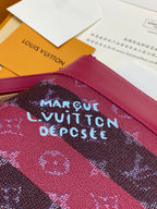 Pink leather zip wristlet with monogram canvas, gold zipper pull, and LV logo