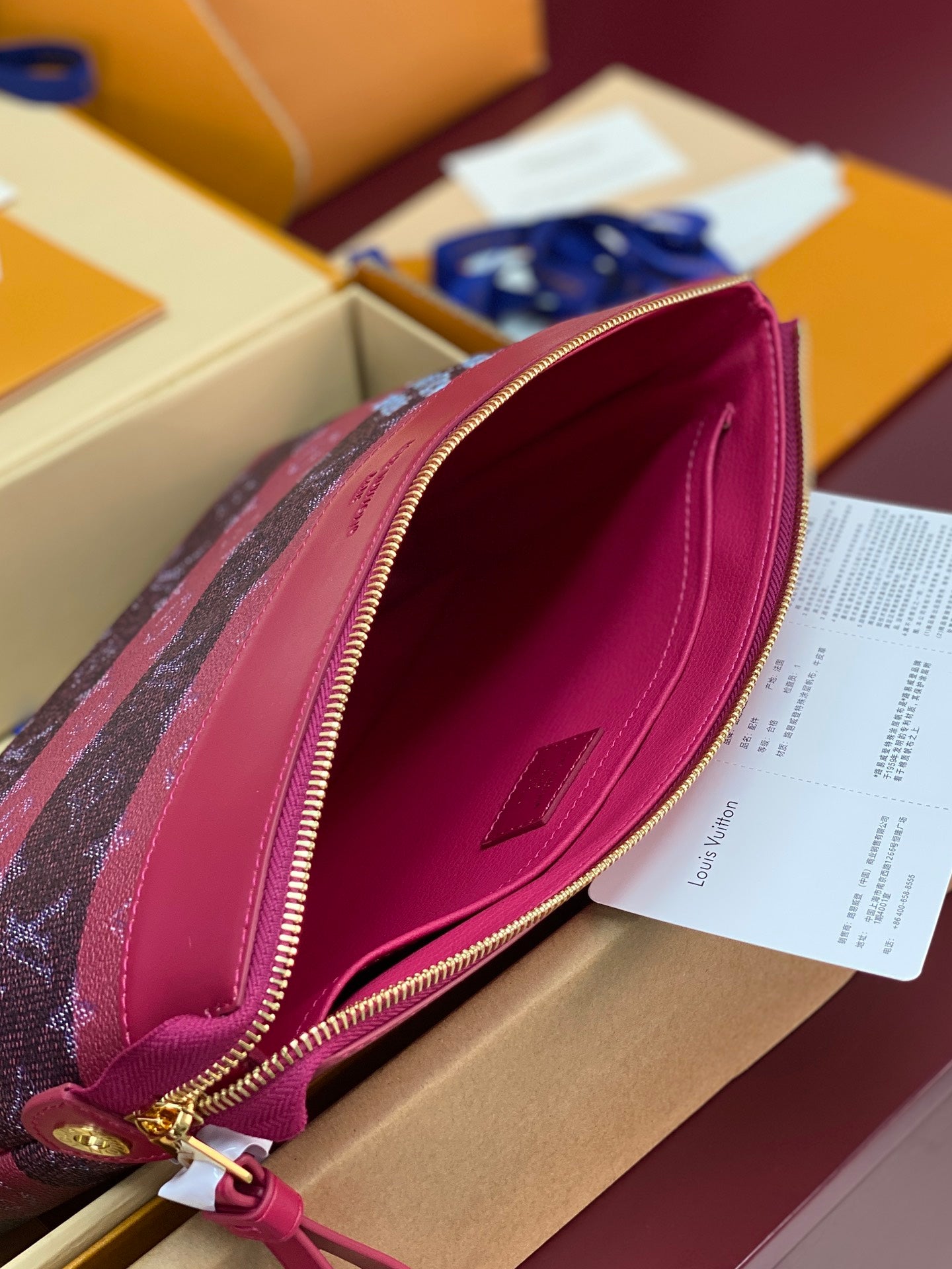 Louis Vuitton small bag open view, pink leather lining with gold-tone zipper