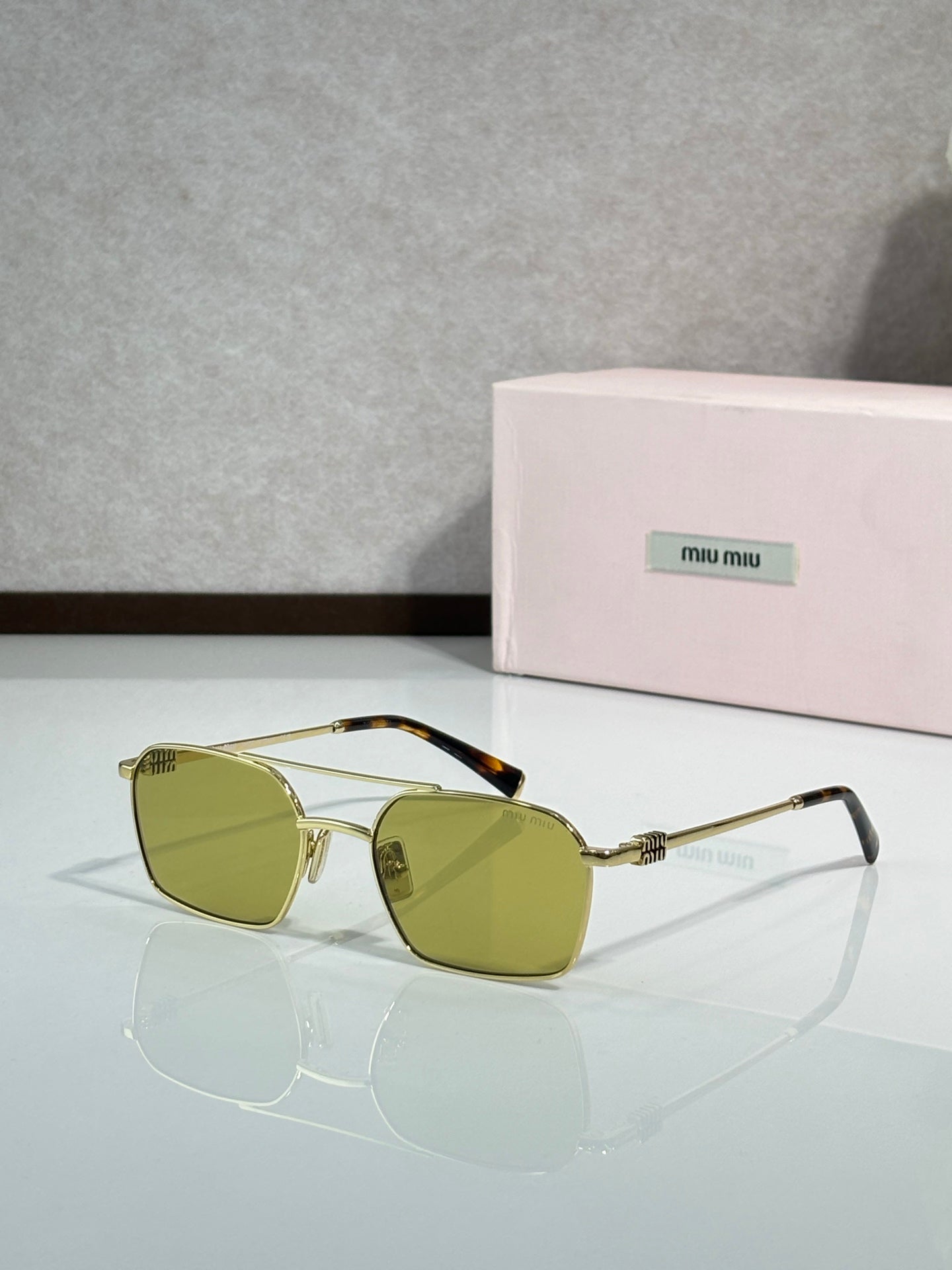 MiuMiu sunglasses, gold metal with yellow-tinted lenses and clear temple arms