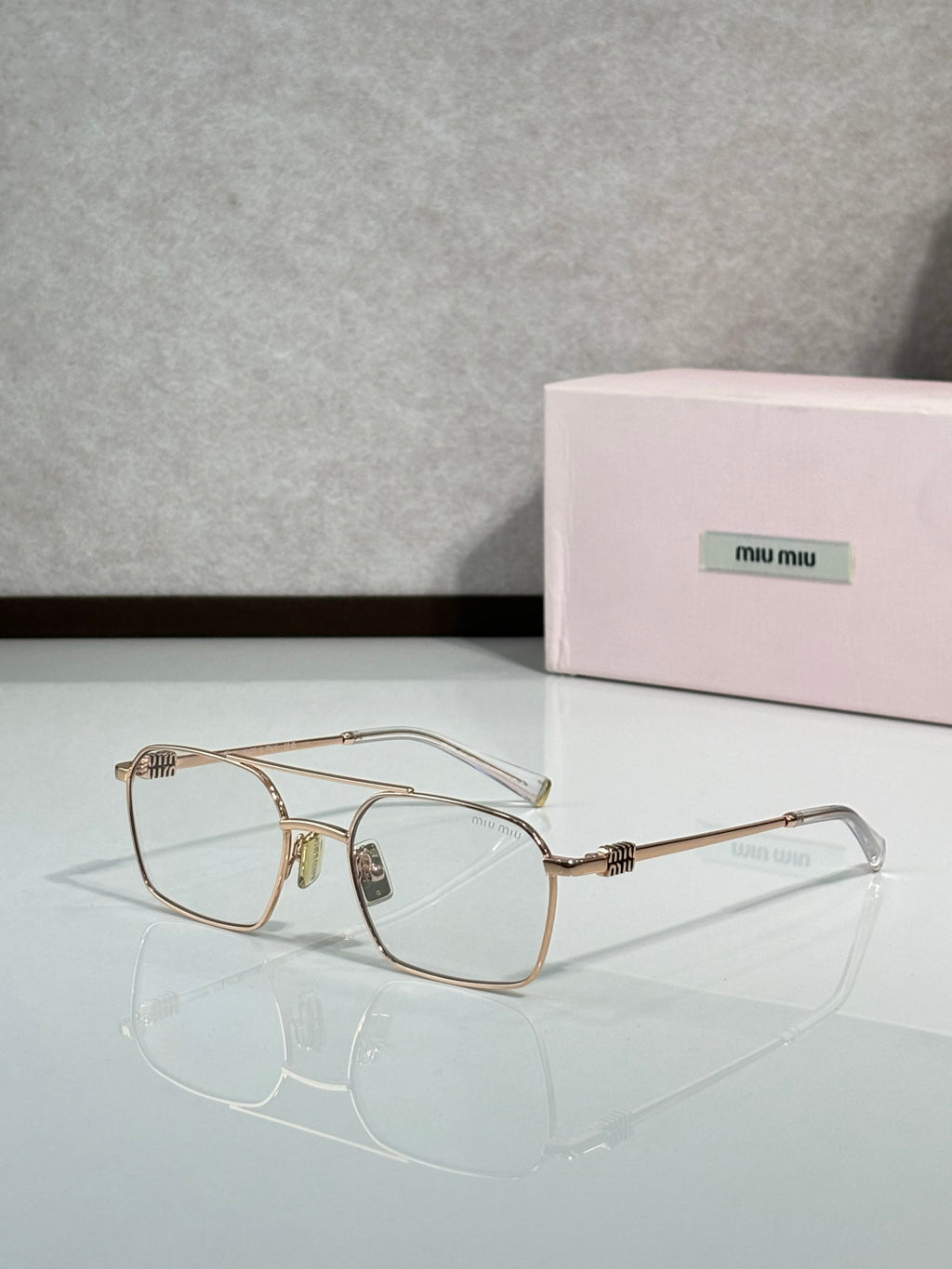 Rose-gold rectangular eyeglasses with clear lenses and metal temples