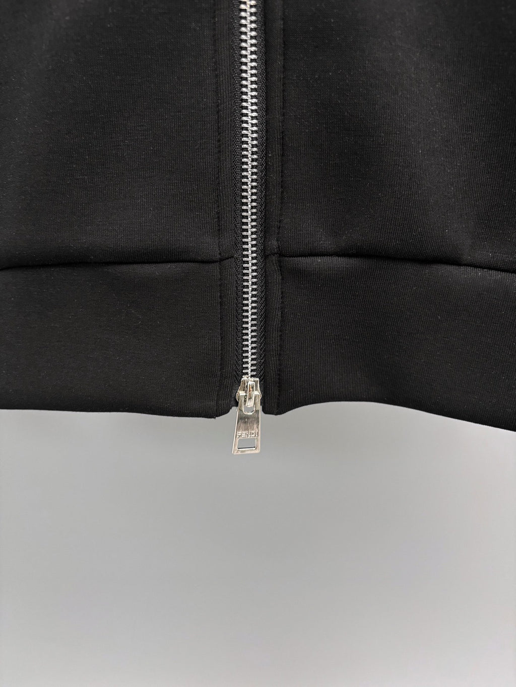 Fendi black sweatshirt close-up of zipper and seam at mid torso