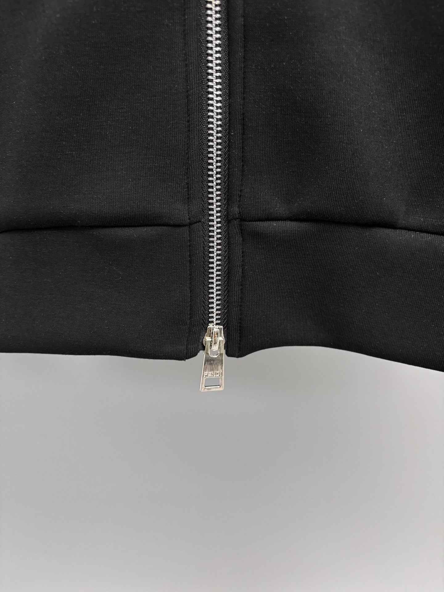 Fendi black sweatshirt close-up of zipper and seam at mid torso