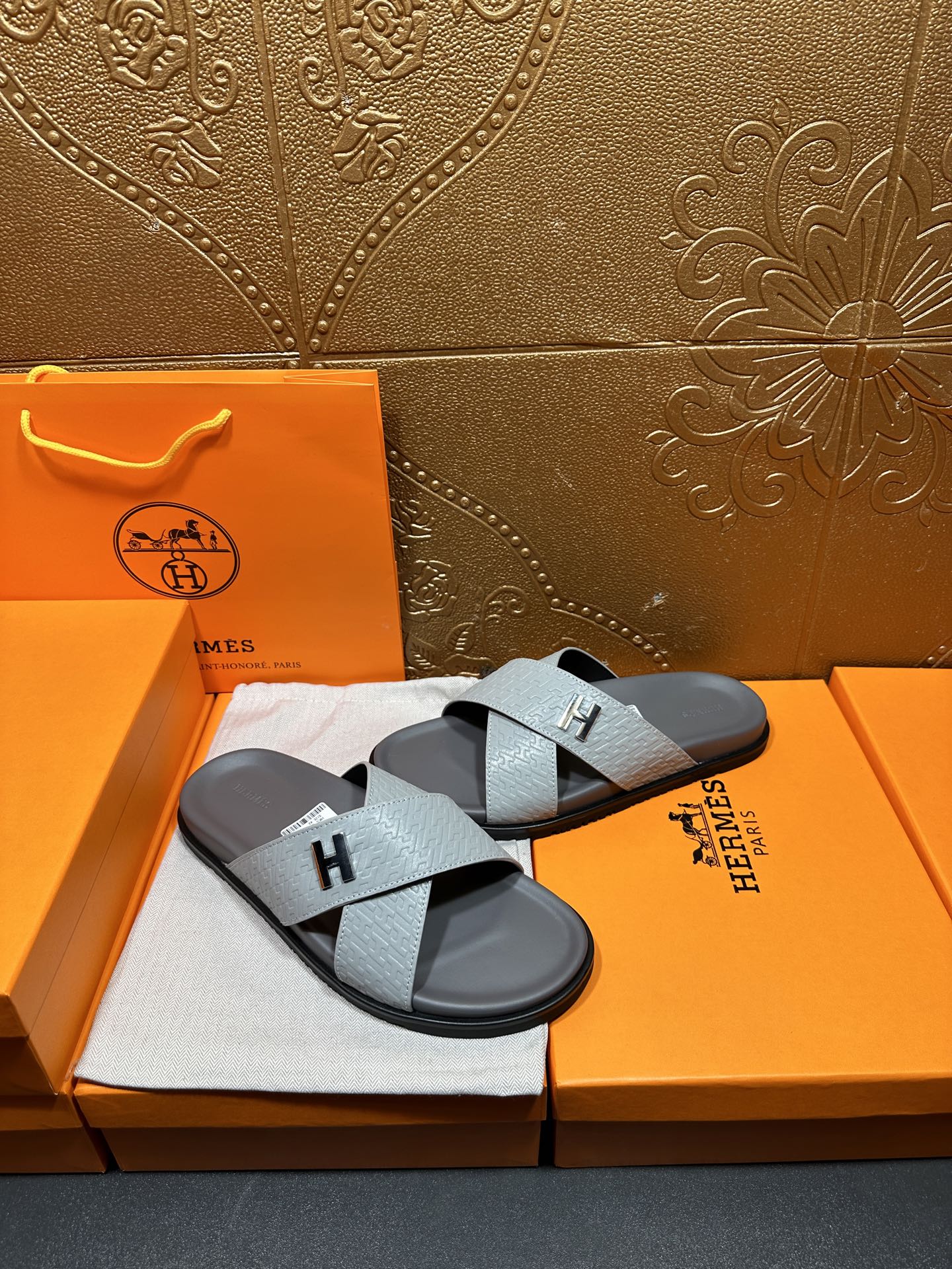 Hermes slide sandals with light blue straps and black H buckle on dark soles