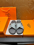 Hermes slide sandals with light blue embossed straps and dark rubber soles